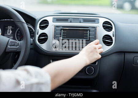 asian femle driver touching dashboard in car Stock Photo