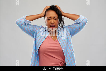 stressed african american woman holding to head Stock Photo