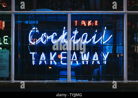 London, UK - June 5, 2019: Take Away Cocktails words in neon light signage on the window of a bar in Soho, an area of Central London famous for bars, Stock Photo