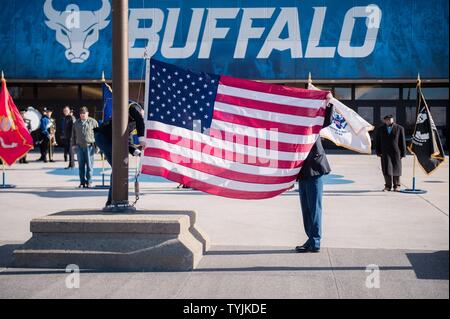 The American flag is prepared to be raised and then lowered to half-staff at 11:11 A.M. to mark the end of World War I as was traditionally celebrated by Armistice Day, during the opening of Veterans Day ceremonies at the University at Buffalo, Amherst, N.Y., Nov. 11, 2016. The State University of New York at Buffalo held a Veterans Day event to remember the service and sacrifice of all veterans over the course of the nation's history. Stock Photo