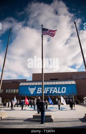 The American flag is raised and then lowered to half-staff at 11:11 A.M. to mark the end of World War I as was traditionally celebrated by Armistice Day, during the opening of Veterans Day ceremonies at the University at Buffalo, Amherst, N.Y., Nov. 11, 2016. The State University of New York at Buffalo held a Veterans Day event to remember the service and sacrifice of all veterans over the course of the nation's history. Stock Photo