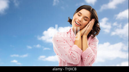 happy woman in pajama making sleeping gesture Stock Photo