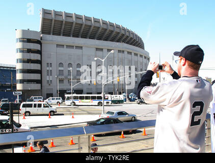 A fan of former New York Yankees outfielder and designated hitter Hideki  Matsui wears a jersey bearing his nickname Godzilla while taking  photographs of batting practice at Yankee stadium before a baseball