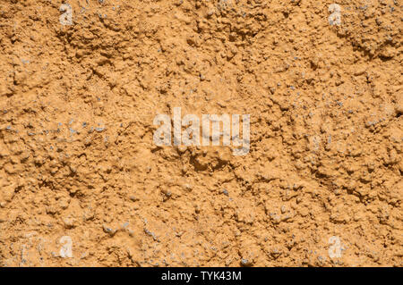 Old vintage grunge ocher painted rough plastered house facade wall closeup as background Stock Photo
