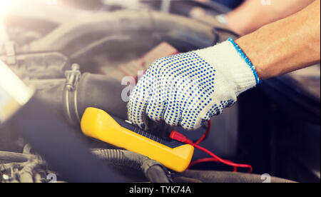 auto mechanic man with multimeter testing battery Stock Photo