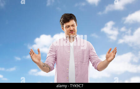 doubting man showing size of something over sky Stock Photo