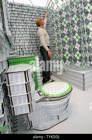 Bryan Berg, a world-record card stacker, pulls back a shower curtain made of card keys inside a model hotel bathroom which he constructed from card keys at the South Street Seaport on September 17, 2009 in New York. The human-scale 400-square-foot model is made of 200,000 card keys and includes a lobby, bedroom and life-size furnishings.     UPI /Monika Graff Stock Photo