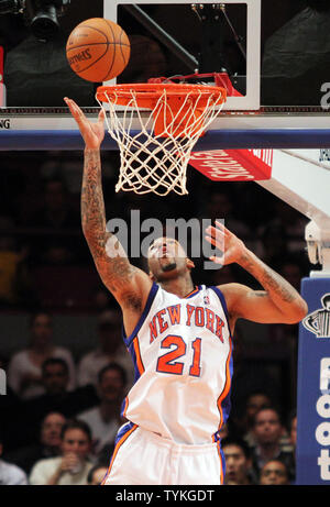 New York Knicks' Wilson Chandler goes up with a shot as he is guarded by New  Jersey Nets' Sean Williams, left, and Bobby Simmons (21) during the fourth  quarter of an NBA