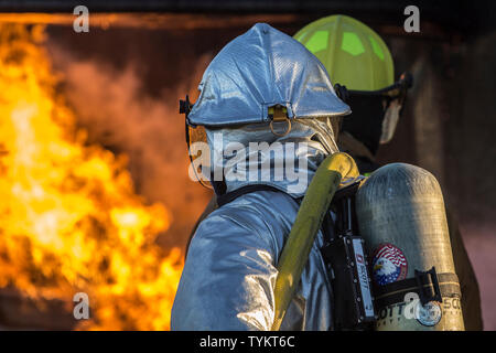 U.S. Marines with Aircraft Rescue and Firefighting (ARFF), Headquarters and Headquarters Squadron (H&HS), Marine Corps Air Station (MCAS) Yuma conduct hand line drills during live burn training on MCAS Yuma, Ariz., June 25, 2019. Hand line drills focus on techniques to push fuel fires away from aircraft, ARFF Marines train monthly to enhance their readiness when responding to emergencies on the flight line. (U.S. Marine Corps photo by Sgt. Allison Lotz) Stock Photo