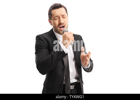 Emotional young male singer singing on a microphone with  closed eyes isolated on white background Stock Photo