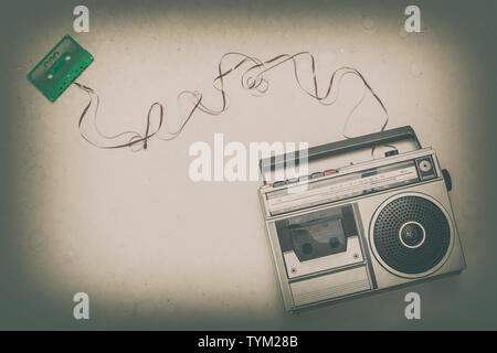 old radio recorder and green cassette with the extracted ribbon. Flat lay style image. Stock Photo