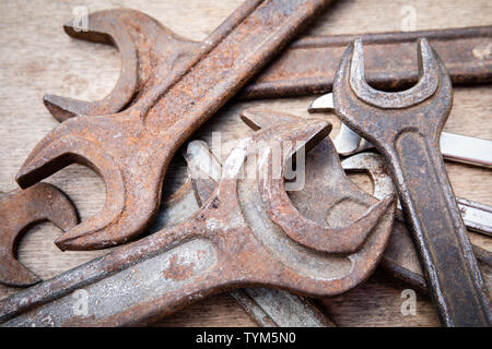 Wrench, different sizes, old and rusty. Construction and hand tools on wooden board, maintenance and reparing concept Stock Photo