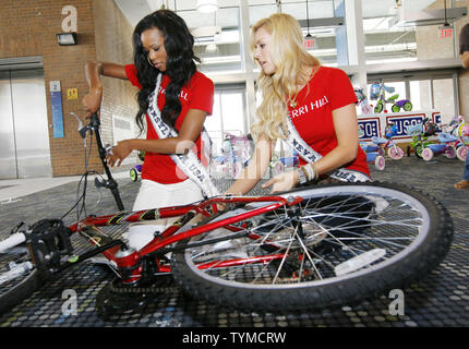 Miss USA contestants Amber-Joi Watkins (L) of Pennsylvania and Sarah Chapman of Nevada work together during the USO Build a Bike event where bikes are assemble and donated to military families at Pier 88 on May 26, 2011 in New York City.    UPI /Monika Graff. Stock Photo