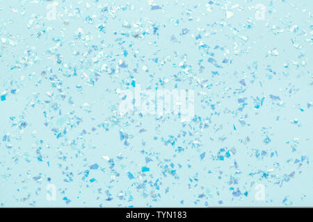 Blue glowing mica glitter on pastel blue trendy abstract background. Stock Photo