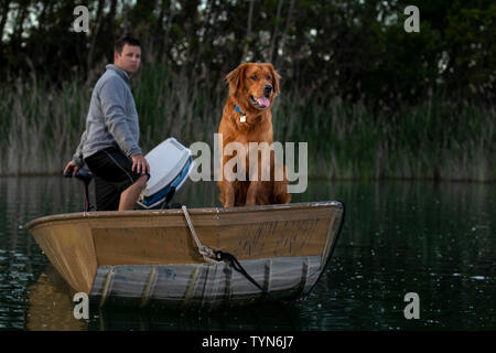 Man with dog in small boat with Dutch flag on IJ harbour 