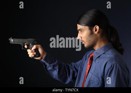 Indian businessman pointing gun Stock Photo