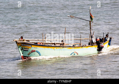 Diu, Daman, Gujarat, India - Circa 2019: Colorful open boat sailing in the blue sea of daman diu. The blue green hull and the open boat with its mast Stock Photo