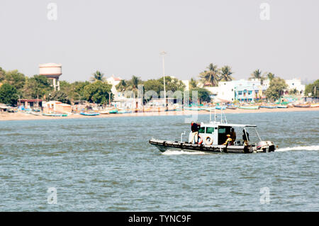 Diu, Daman, Gujarat, India - Circa 2019: Colorful open boat sailing in the blue sea of daman diu. The blue green hull and the open boat with its mast Stock Photo