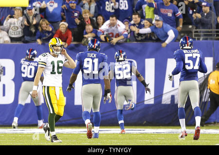 Green Bay Packers Scott Tolzien walks back to the bench while New York  Giants Justin Tuck, Jacquian Williams and Jon Beason celebrate with Jason  Pierre-Paul who runs back an interception 24 yards for a touchdown in the  fourth quarter in week 10 of the