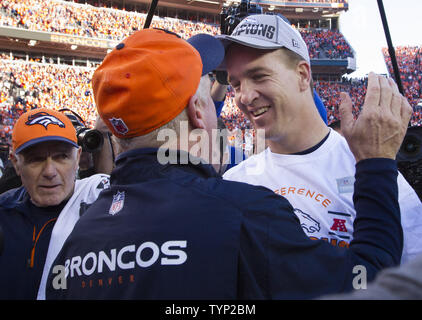 Denver Broncos quarterback Peyton Manning (R) wins the NFL's Offensive Player of the Year as announced in New York on February 1, 2014.  Broncos head coach John Fox (C) congratulates Manning after the AFC Championship game at Sports Authority Field at Mile High in Denver on January 19, 2014.    (FILE PHOTO)    UPI/Gary C. Caskey Stock Photo