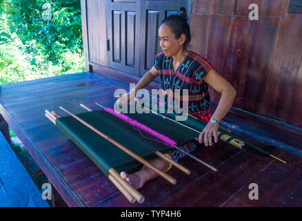 Woman from the Cotu Minority weaves with a strap loom in Quang Nam Vietnam Stock Photo