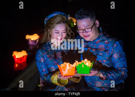 Vietnamese couple holding lanterns before droping them into the river in Hoi An ,Vietnam during the Hoi An Full Moon Lantern Festival Stock Photo