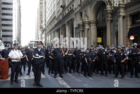 A line of NYPD Police Officers watch protesters block traffic on lower Broadway near Wall Street during a rally and protest called 'Flood Wall Street' in New York City on September 22, 2014.  The protest was similar to the Occupy Wall Street set of protests but this one was more related to Climate Week and Global Warming Issues.   UPI/John Angelillo Stock Photo