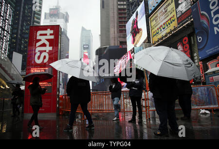 People walk by a giant new billboard that hangs below the Marriott Marquis in Times Square in New York City on November 17, 2014. The new screen stands eight stories tall and is nearly as long as a football field, spanning the entire block from 45th Street to 46th Street on Broadway. Nearly 24 million LED pixels, each containing tiny red, blue and green lights, make up the display, giving it higher resolution than even the best of today's top-of-the-line television sets.    UPI/John Angelillo Stock Photo