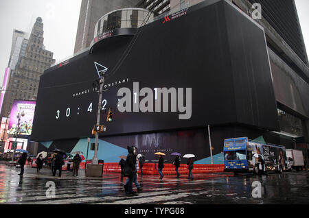 People walk by a giant new billboard that hangs below the Marriott Marquis in Times Square in New York City on November 17, 2014. The new screen stands eight stories tall and is nearly as long as a football field, spanning the entire block from 45th Street to 46th Street on Broadway. Nearly 24 million LED pixels, each containing tiny red, blue and green lights, make up the display, giving it higher resolution than even the best of today's top-of-the-line television sets.    UPI/John Angelillo Stock Photo