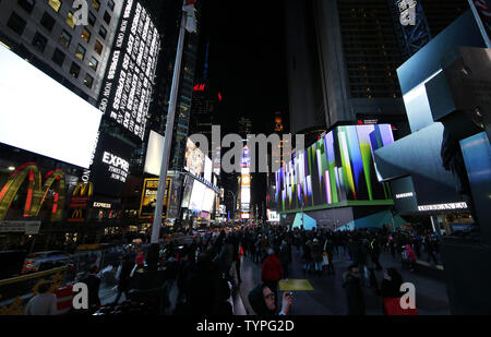 People look up at a giant new billboard that hangs below the Marriott Marquis when it is illuminated for the first time in Times Square in New York City on November 18, 2014. The new screen stands eight stories tall and is nearly as long as a football field, spanning the entire block from 45th Street to 46th Street on Broadway. Nearly 24 million LED pixels, each containing tiny red, blue and green lights, make up the display, giving it higher resolution than even the best of today's top-of-the-line television sets.    UPI/John Angelillo Stock Photo