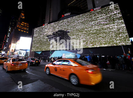 People look up at a giant new billboard that hangs below the Marriott Marquis when it is illuminated for the first time in Times Square in New York City on November 18, 2014. The new screen stands eight stories tall and is nearly as long as a football field, spanning the entire block from 45th Street to 46th Street on Broadway. Nearly 24 million LED pixels, each containing tiny red, blue and green lights, make up the display, giving it higher resolution than even the best of today's top-of-the-line television sets.    UPI/John Angelillo Stock Photo