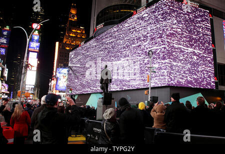 People look up at a giant new billboard that hangs below the Marriott Marquis when it is illuminated for the first time in Times Square in New York City on November 18, 2014. The new screen stands eight stories tall and is nearly as long as a football field, spanning the entire block from 45th Street to 46th Street on Broadway. Nearly 24 million LED pixels, each containing tiny red, blue and green lights, make up the display, giving it higher resolution than even the best of today's top-of-the-line television sets.    UPI/John Angelillo Stock Photo