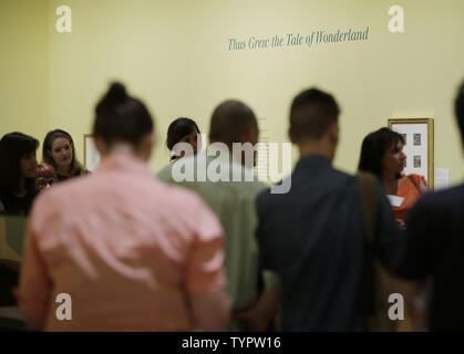 People stand in the room where the original 'Alice in Wonderland' manuscript is on display at the press preview one day before a public exhibition titled 'Alice: 150 Years of Wonderland' celebrating the 150th anniversary of the publication of Lewis Carrol's 'Alice's Adventures in Wonderland' begins at The Morgan Library & Museum in New York City on June 25, 2015. The display features the original manuscript of the book  on loan from the British Library in London as well as  original correspondence, unique drawings, hand colored proofs, rare editions, vintage photographs and some never before e Stock Photo