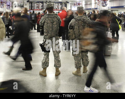 Two U.S. Army National Guard men stand guard among travelers at Penn Station on December 22, 2015 in New York City. Security is still high at landmarks and tourist areas around Manhattan since the November Paris terrorist attacks that killed over 100 people.    Photo by John Angelillo/UPI Stock Photo
