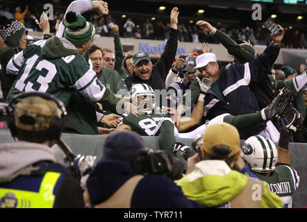 New York Jets Eric Decker leaps into the seats and celebrates with the fans  after catching a 6 yard game-winning touchdown pass in overtime against the  New England Patriots at MetLife Stadium