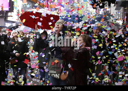 People gather to catch confetti under the Hard Rock Cafe as confetti is ...