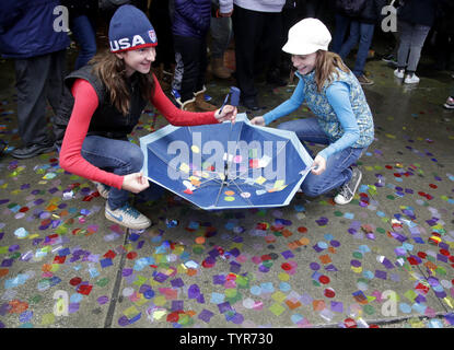 Two girls catch confetti in an umbrella under the Hard Rock Cafe as confetti is thrown from the marquee as part of the annual New Year's Eve Confetti Test in Times Square in New York City on December 29, 2015. An estimated one million people will be in Times Square on New Years Eve over a billion will be watching throughout the world.     Photo by John Angelillo/UPI Stock Photo