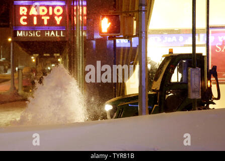 A snow plow cleans the sidewalk around Radio City Music Hall as as dangerous winter storm Jonas brings crippling snow, heavy icing and blizzard conditions in New York City on January 23, 2016. A massive winter storm clobbered the East Coast on Saturday, dumping more than three feet of snow in parts of West Virginia and Maryland, tying up traffic on highways, grounding thousands of flights and shutting down travel in the nation's largest city. At least 14 people have been killed in the massive storm so far.    Photo by John Angelillo/UPI Stock Photo