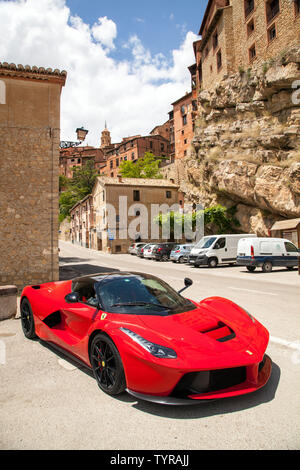 Red Ferrari motor car parked in the Medieval Moorish Ancient Spanish walled  city town of Albarracin Aragon Spain Stock Photo