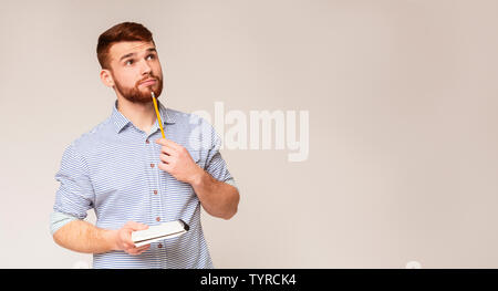 Young man thinking about checklist what to do Stock Photo