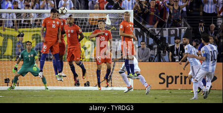 Argentina midfielder Lionel Messi (10) kicks a penalty kick into Chile forward Nicolas Castillo (16), midfielder Arturo Vidal (8), midfielder Charles Aranguiz (20) and midfielder Francisco Silva (5) as goalkeeper Claudio Bravo (1) watches in the second overtime period at the Copa America Centenario USA 2016 Finals at MetLife Stadium in East Rutherford, New Jersey on June 26, 2016.  Chile won 4-2 in penalty kicks.    Photo by Ray Stubblebine/UPI Stock Photo