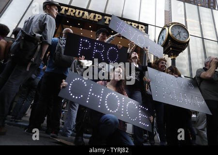 Protesters hold up signs as they gather at Trump Tower on October 19, 2016 in New York City. A large group of mostly women showed up outside Trump Tower on Fifth Avenue and staged a protest denouncing Republican presidential nominee Donald Trump for the language he used in a bombshell hot mic tape that was leaked last Friday and has upended the presidential race just a few weeks before Election Day.   Photo by John Angelillo/UPI Stock Photo
