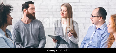 Psychiatrist talking to addicted patients at group session Stock Photo