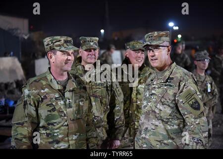 Air Force Gen. Joseph Lengyel, chief, National Guard Bureau; Army Lt. Gen. Timothy Kadavy, director, Army National Guard; Air Force Chief Master Sgt. Mitchell Brush, senior enlisted advisor to the chief of the National Guard Bureau; and Army Maj. Gen. John Thomson, commanding general, 1st Cavalry Division, watch toops play a flag footbal game during a Thanksgiving troop visit, Bagram Airfield, Bagram, Afghanistan, Nov. 23, 2016. Stock Photo