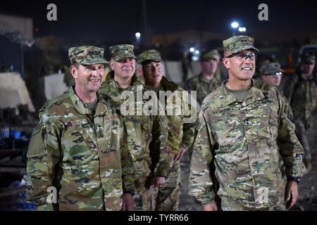 Air Force Gen. Joseph Lengyel, chief, National Guard Bureau; Army Lt. Gen. Timothy Kadavy, director, Army National Guard; Air Force Chief Master Sgt. Mitchell Brush, senior enlisted advisor to the chief of the National Guard Bureau; and Army Maj. Gen. John Thomson, commanding general, 1st Cavalry Division, watch toops play a flag footbal game during a Thanksgiving troop visit, Bagram Airfield, Bagram, Afghanistan, Nov. 23, 2016. Stock Photo