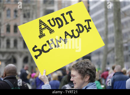 Protesters hold up signs as they participate in a Tax March protest in New York City on April 15, 2017. Protesters across the U.S. took to the streets to demand that President Trump make his tax returns public.       Photo by John Angelillo/UPI Stock Photo