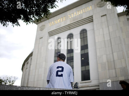 A fan of former New York Yankees outfielder and designated hitter Hideki  Matsui wears a jersey bearing his nickname Godzilla while taking  photographs of batting practice at Yankee stadium before a baseball