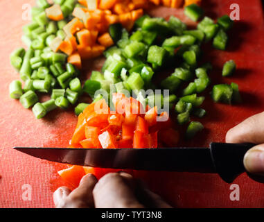 https://l450v.alamy.com/450v/tyt3n8/capsicum-tomatoes-and-carrot-cut-into-small-piecesfinely-chopped-vegetables-on-a-chopping-board-by-knife-in-hand-tyt3n8.jpg