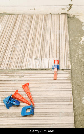 Plastic wedges and clips on ceramic tiles. Tile Spacer Leveling System. Stock Photo