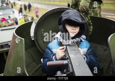 A Lithuanian boy checks out a tank-mounted machine gun at a static display in Visaginas, Lithuania, Nov. 26, 2016. Militaries from several countries taking part in Exercise Iron Sword 16, including United States, Lithuania, United Kingdom, Poland, Luxembourg, Latvia, and Canada interacted with and demonstrated their gear to locals and other visitors. Black Sea Rotational Force is an annual multilateral security cooperation activity between the U.S. Marine Corps and partner nations in the Black Sea, Balkan and Caucasus regions designed to enhance participants’ collective professional military c Stock Photo